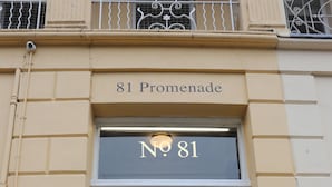 A black door with a gold number plate reading "No 81" and a sign above stating "81 Promenade". - Rooms on The Prom (Cheltenham)