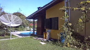 A building with a satellite dish, a small pool, and a garden area. - Pousada Serra da Mantiqueira (Pindamonhangaba)