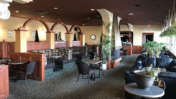 A spacious lobby with seating areas, a reception desk, and a clock on the wall. - Key West Inn (Devon)