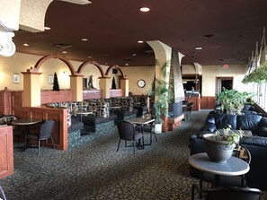 A spacious lobby with seating areas, a reception desk, and a clock on the wall. - Key West Inn (Devon)