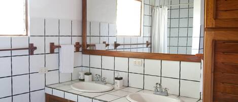 Une salle de bain avec deux lavabos, un grand miroir et des meubles en bois.