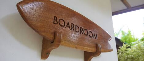 Una placa de madera con la palabra 'BOARDROOM' colocada en una pared.
