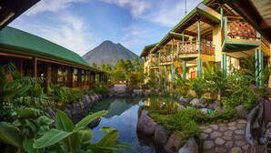 A resort with a pool, lush greenery, and a mountain view. - Arenal Observatory Lodge & Trails (La Fortuna)