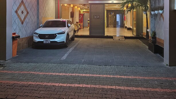 Der Eingang des Trung Mai Hotels mit einem weißen Auto davor.
