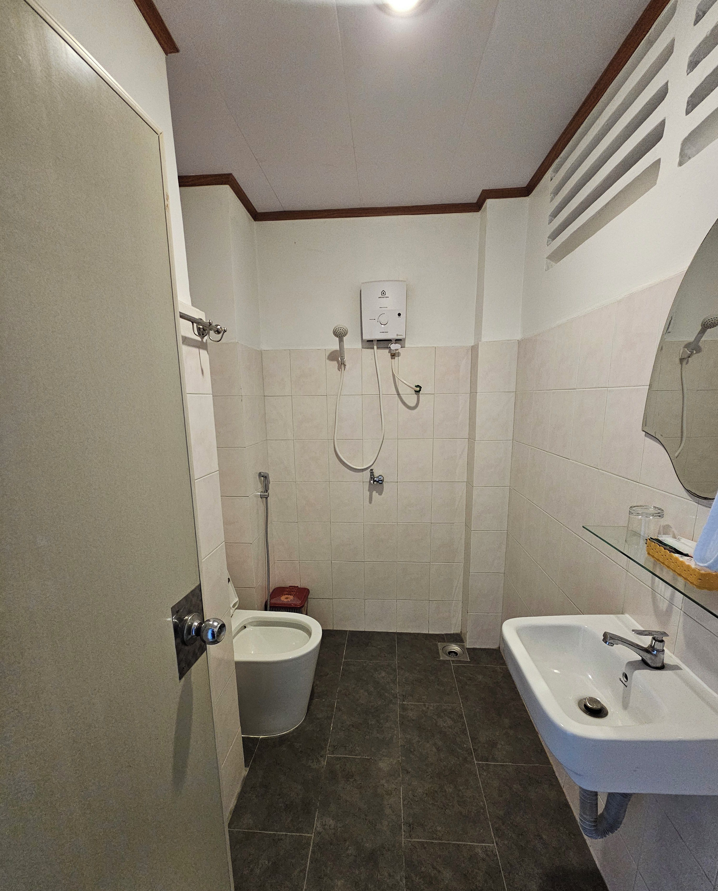 A bathroom with a toilet, a shower, and a sink.