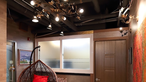 A room with a hanging chair, a wooden door, and a window with frosted glass. - SB Guest House (Suwon)