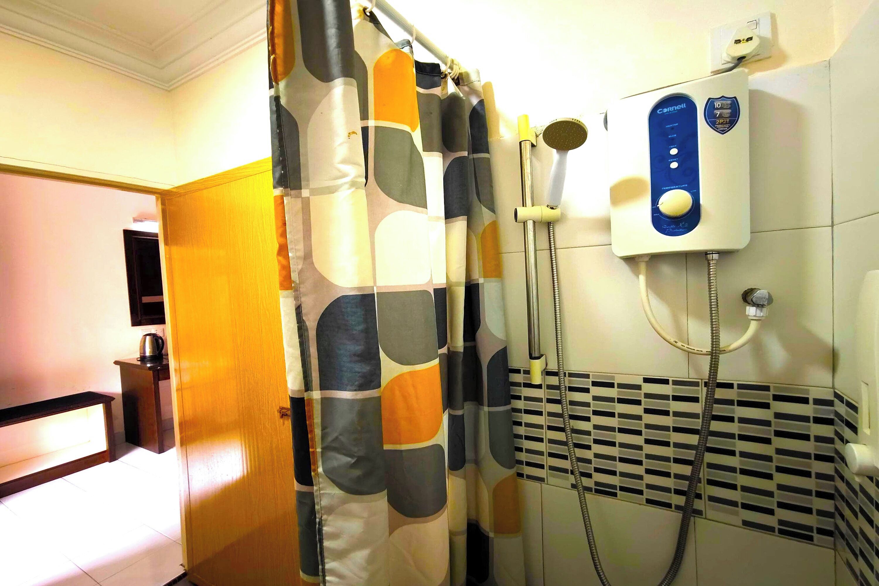 Une salle de bain équipée d’une douche, d’un porte-serviettes et d’un radiateur fixé au mur.