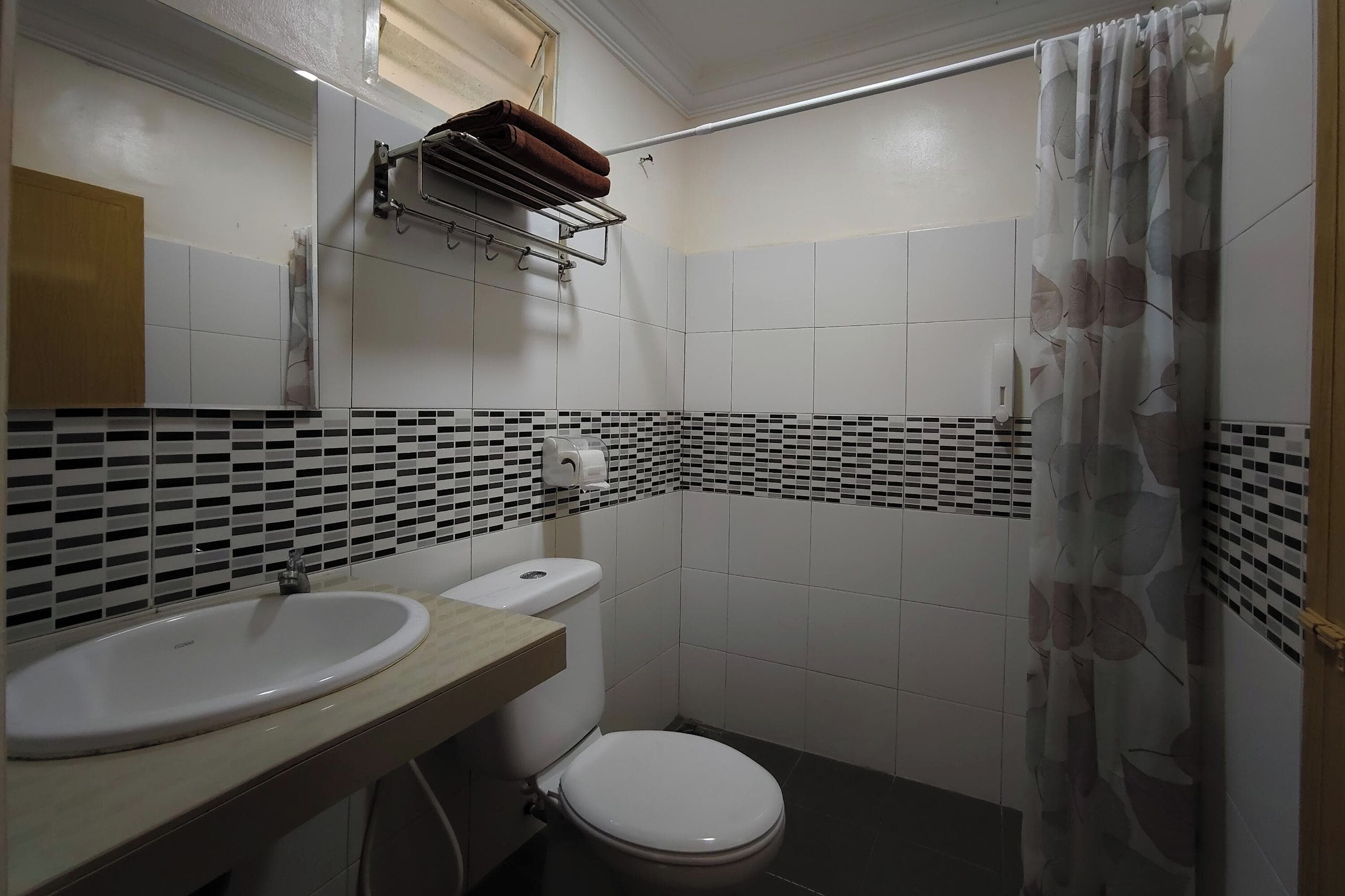 A bathroom with a white sink, a toilet, and a shower curtain.