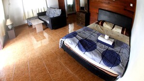 A bedroom with a bed, a sofa, a dresser, and a mirror. - Rainbow Lodge Langkawi (Langkawi)