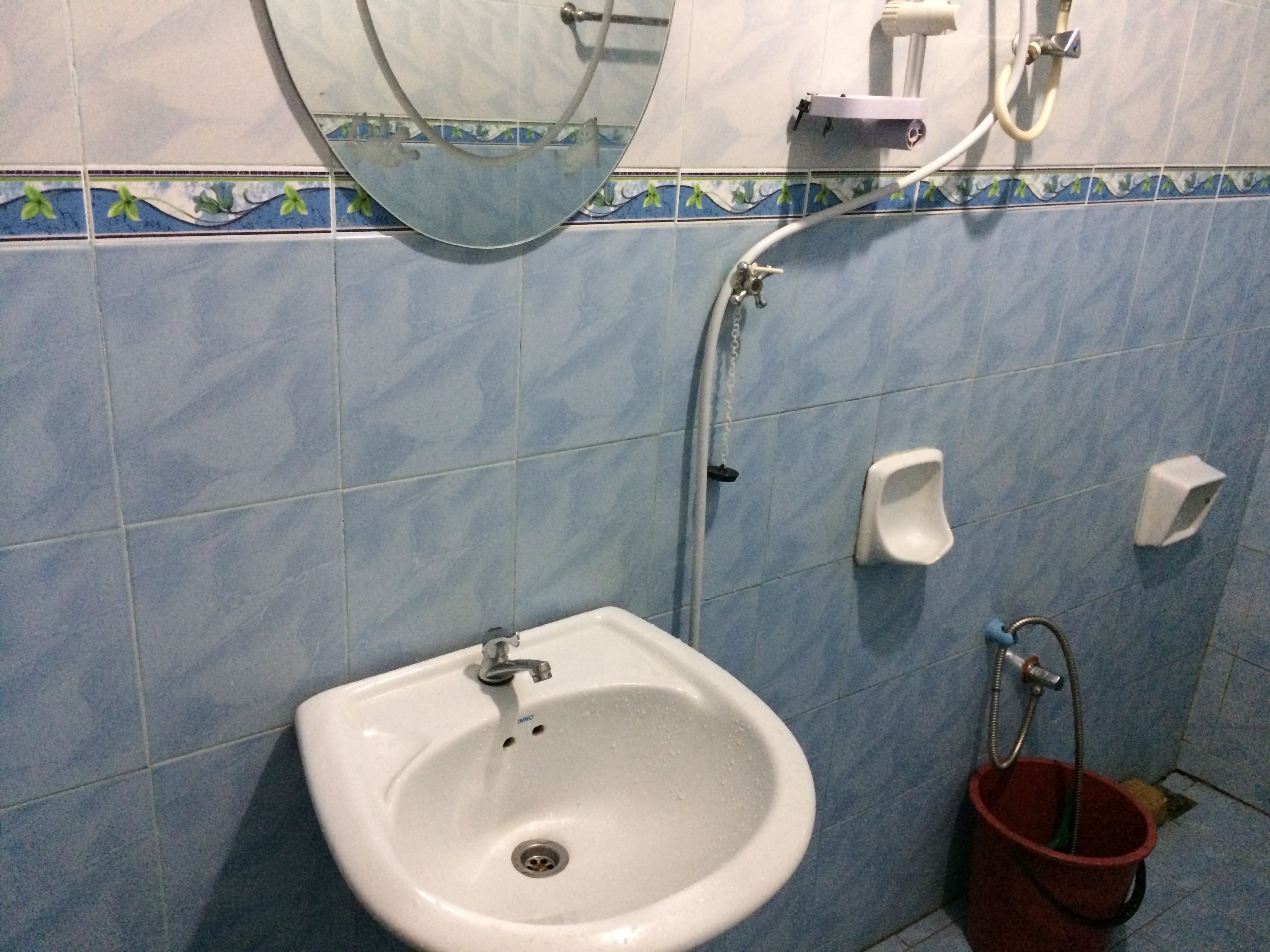 Une salle de bain avec un lavabo blanc, un miroir et une douche.