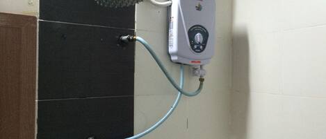A shower with a handheld showerhead and a wall-mounted control panel.