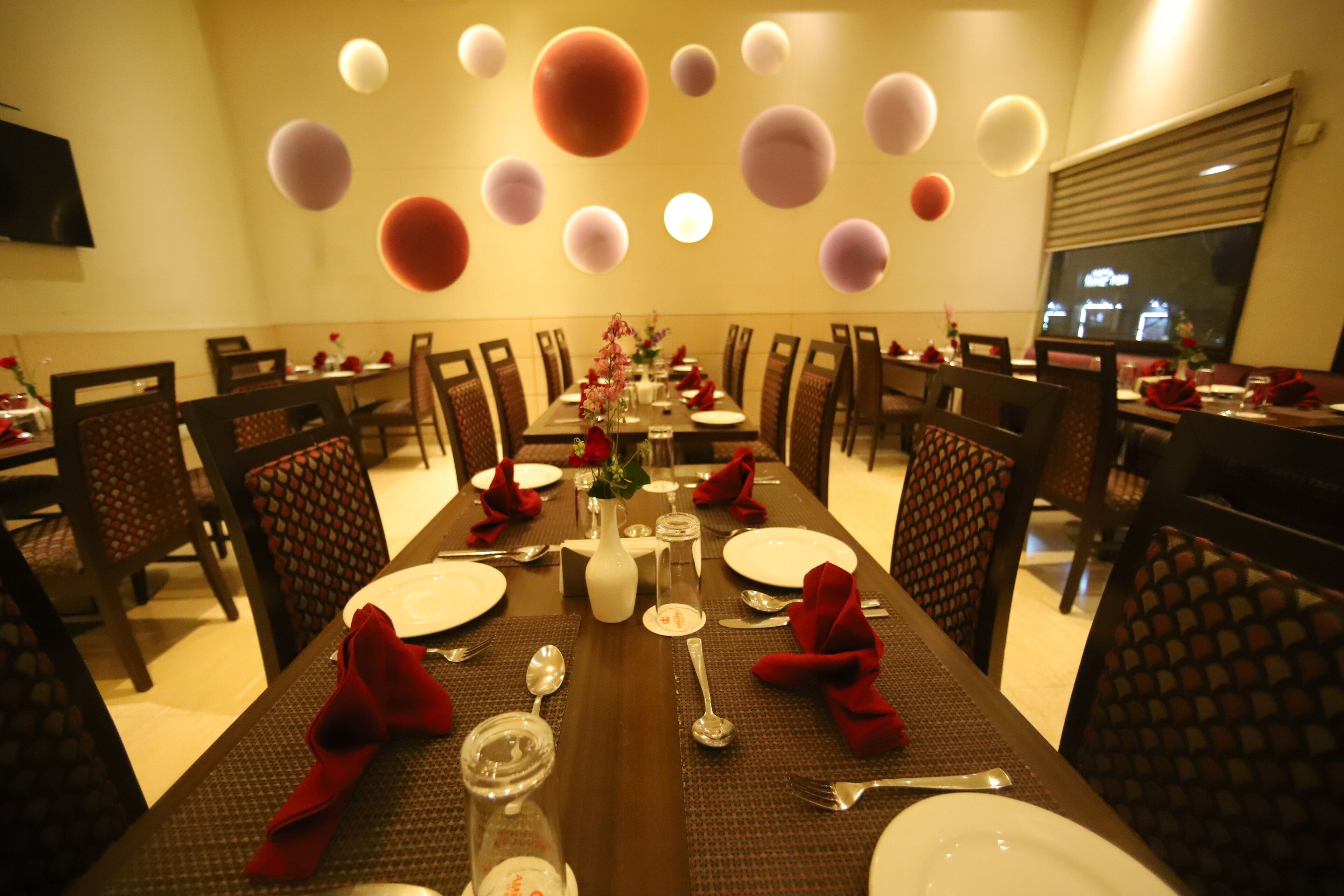 A dining area with a long table set for a meal, surrounded by chairs.