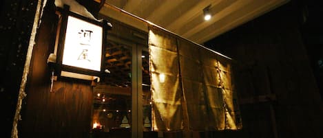 A dimly lit interior with a signboard and wooden beams.