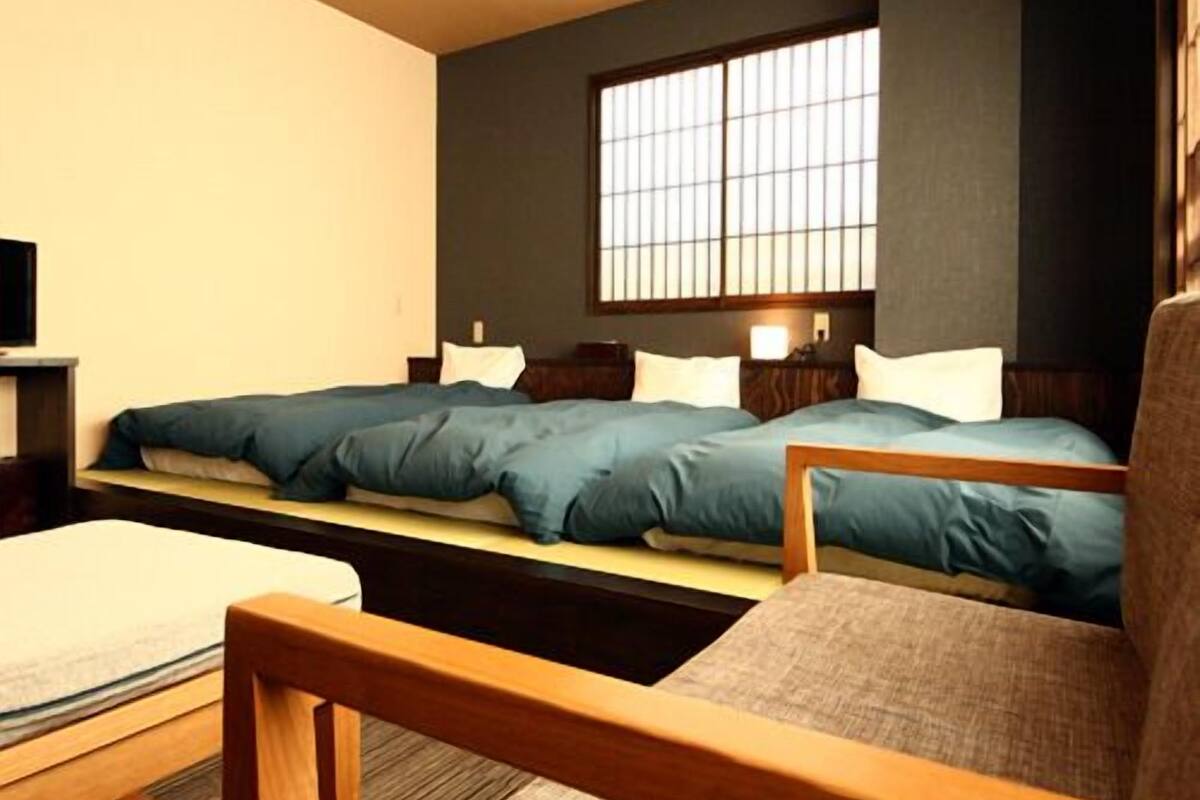 Ein Hotelzimmer mit Bett, Sessel, Schreibtisch und Fenster.