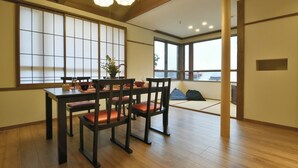 A traditional Japanese-style room with tatami flooring, a low table with cushions, and sliding doors.