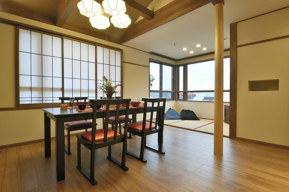 A traditional Japanese-style room with tatami flooring, a low table with cushions, and sliding doors.