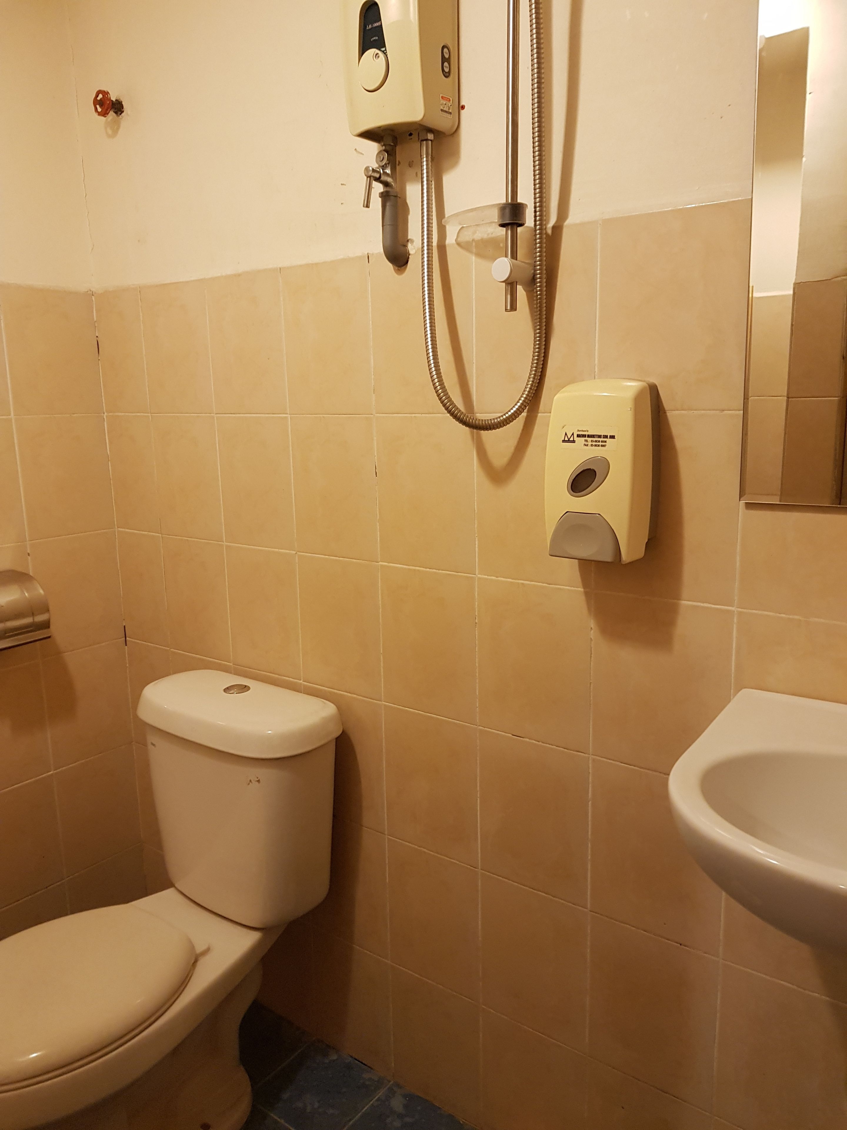 Un baño con inodoro, bidé y secamanos.