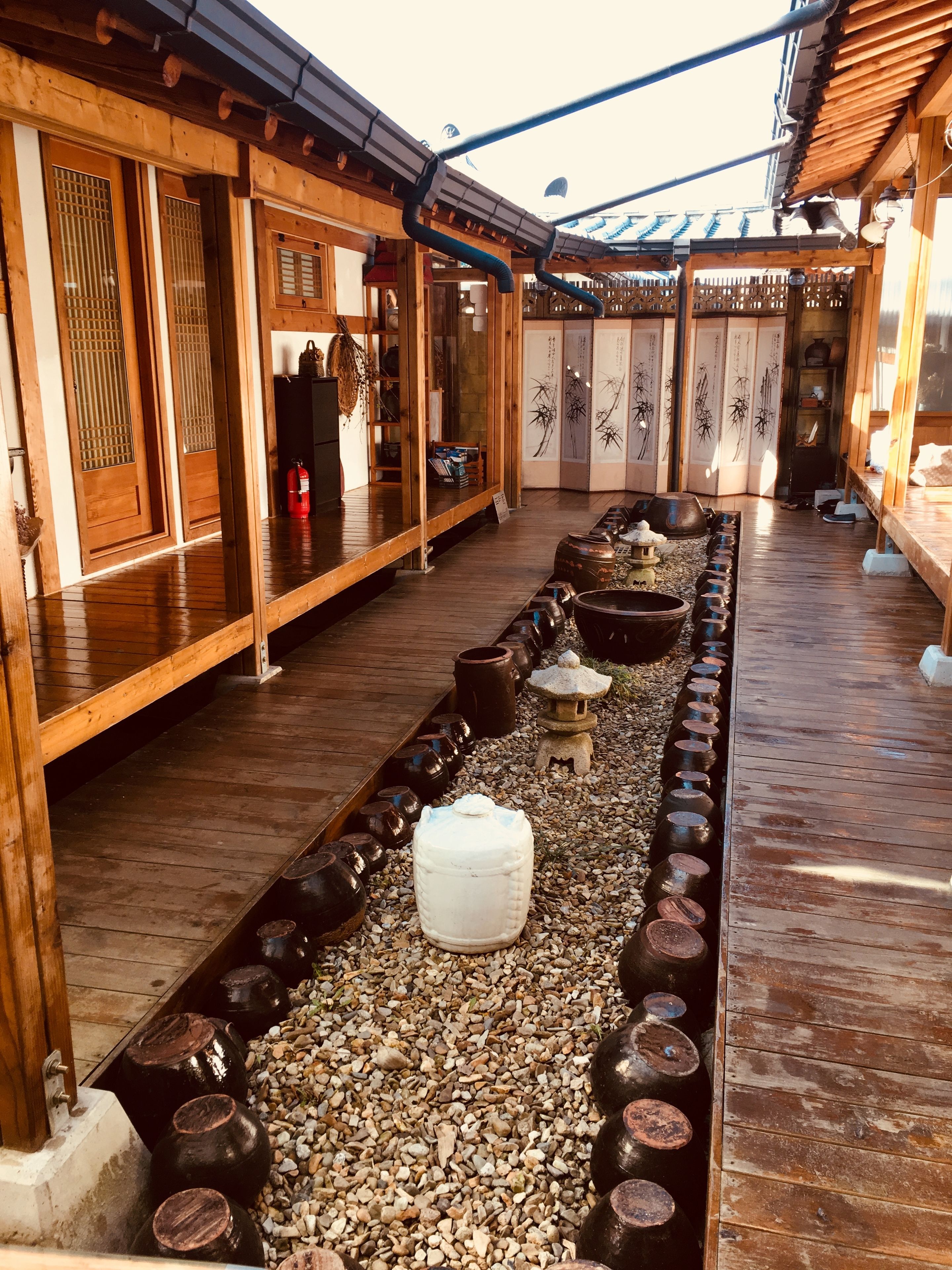 A traditional Japanese-style building with wooden floors, tatami mats, and a koi pond.