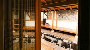 A traditional Japanese room with tatami flooring, a shoji screen, and a wooden ceiling.