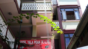Ein mehrstöckiges Gebäude mit Balkonen und einem Schild für Hotel Yala Peak (P) Ltd.