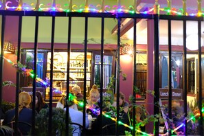 A restaurant with outdoor seating, a sign indicating 'Lunch' and 'Dinner' availability, and decorative lights. - Hotel Yala Peak (Kathmandu)
