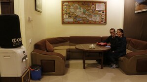 Ein Wohnzimmer mit braunen Sofas, einem kleinen runden Tisch und einer Kaffeemaschine.
