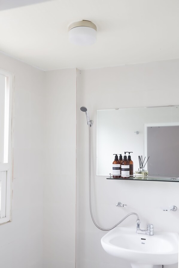 Habitación cuádruple básica, varias camas, para no fumadores | Baño | Regadera, amenidades de baño gratuitas, secadora de cabello, toallas 