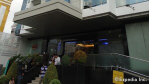 Un hotel de varios pisos con diseño moderno, que destaca por su entrada con fachada de vidrio y techo plano.