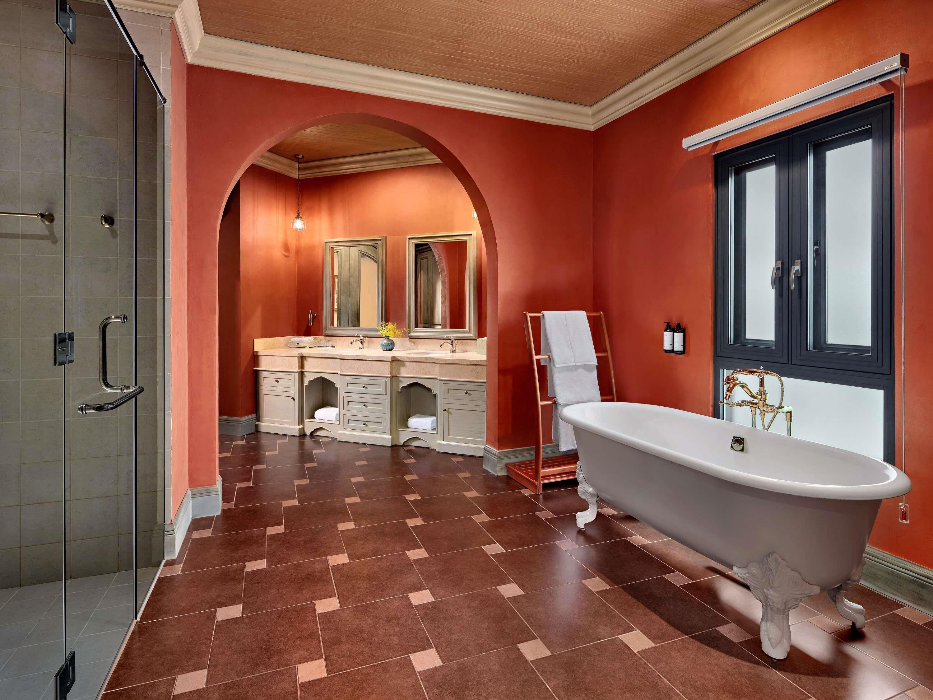 A bathroom with a freestanding bathtub, a vanity with a mirror, and a shower enclosure.
