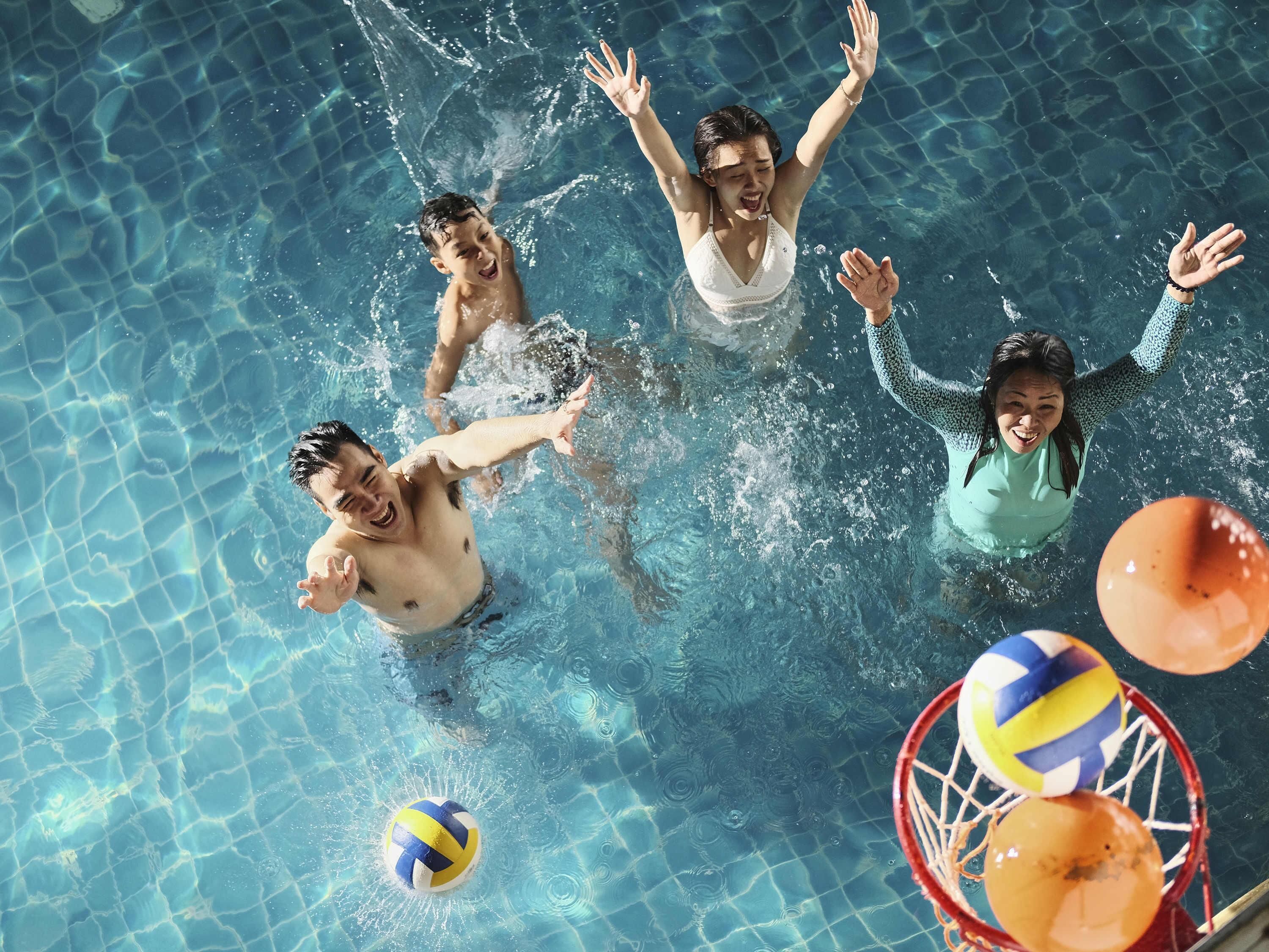 Una piscina amb aigua cristal·lina i una xarxa de voleibol.