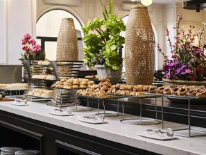 A buffet with various pastries and flowers. - Mercure Danang French Village Bana Hills (Da Nang)