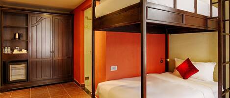 A bunk bed room with a wooden headboard, a wardrobe, and a small kitchenette.