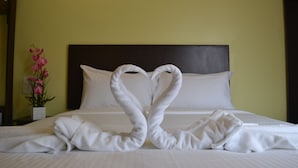 Habitación de hotel con una cama y una toalla dispuesta en forma de corazón.