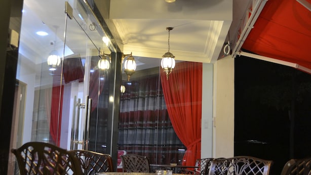Un comedor con una mesa y sillas, un ventilador de techo e iluminación decorativa.