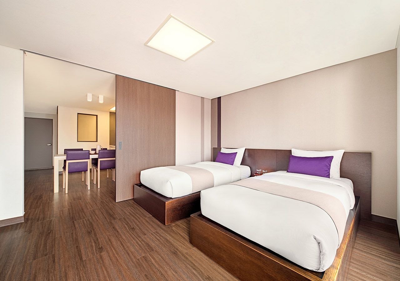 Una habitación de hotel con una cama grande, un escritorio y una silla.