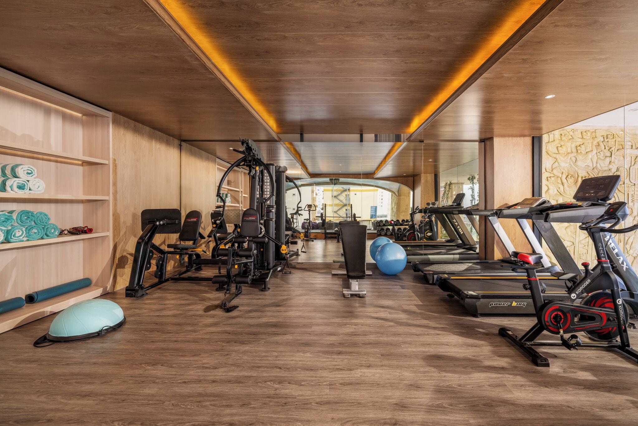 A gym with cardio machines, weightlifting equipment, and exercise balls.