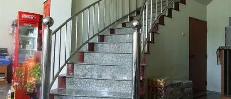 A staircase with metal railings and marble steps, leading to an upper floor.