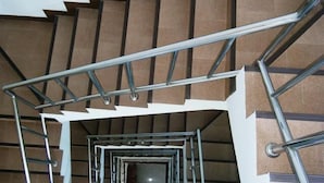 A spiral staircase with metal railings and brown steps. - Sukwilai Hotel (Hua Hin)