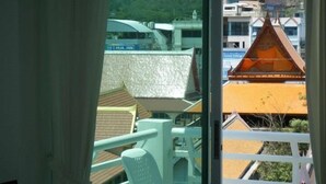 A balcony with a view of traditional buildings and a hill. - Sukwilai Hotel (Hua Hin)