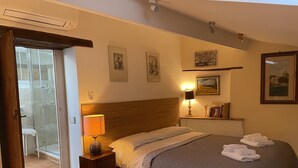 A bedroom with a bed, bedside lamp, and a nightstand. - Orvieto in Terrazza (Orvieto)