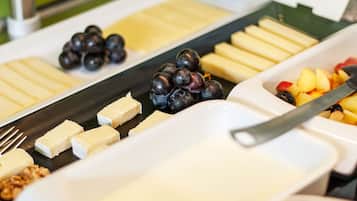 Een buffet met diverse soorten eten, waaronder kaas, fruit en noten.