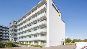 Un moderno edificio de hotel con varios balcones y un cielo despejado.