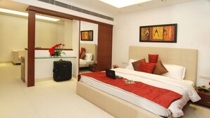 A modern hotel room with a large bed, a desk, and a sitting area. - Silver Ark (Gurugram)