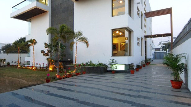 A modern multi-story building with large windows, a flat roof, and a covered walkway. - Silver Ark (Gurugram)