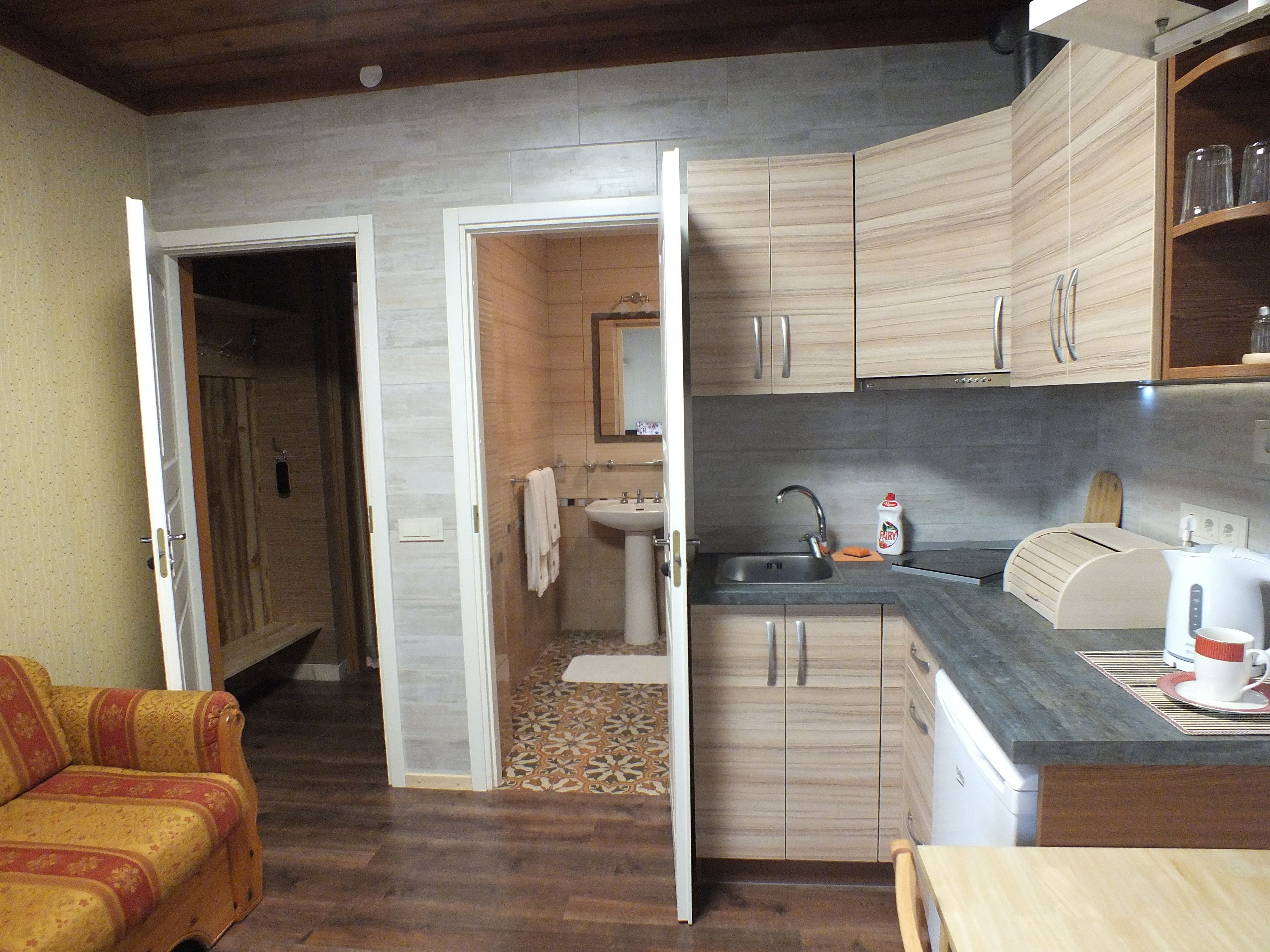 A compact kitchen with wooden cabinets, a sink, and a toaster.
