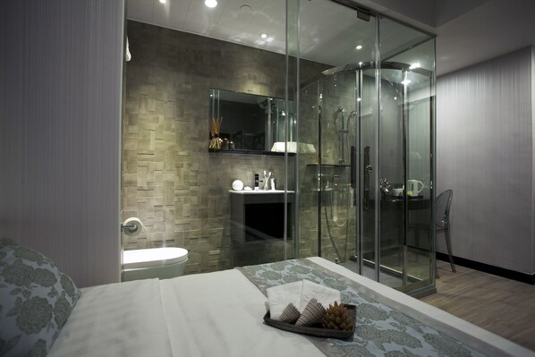 A modern bathroom with a glass shower enclosure, a built-in sink, and a mirror above the vanity.