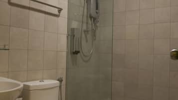 A bathroom with a toilet, sink, and glass-enclosed shower stall.