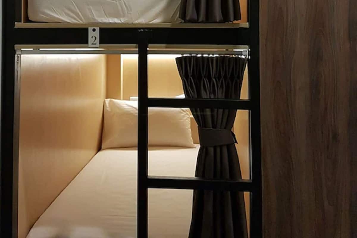 A bunk bed room with a curtain divider, a wooden panel on the right, and a number '2' on the left.