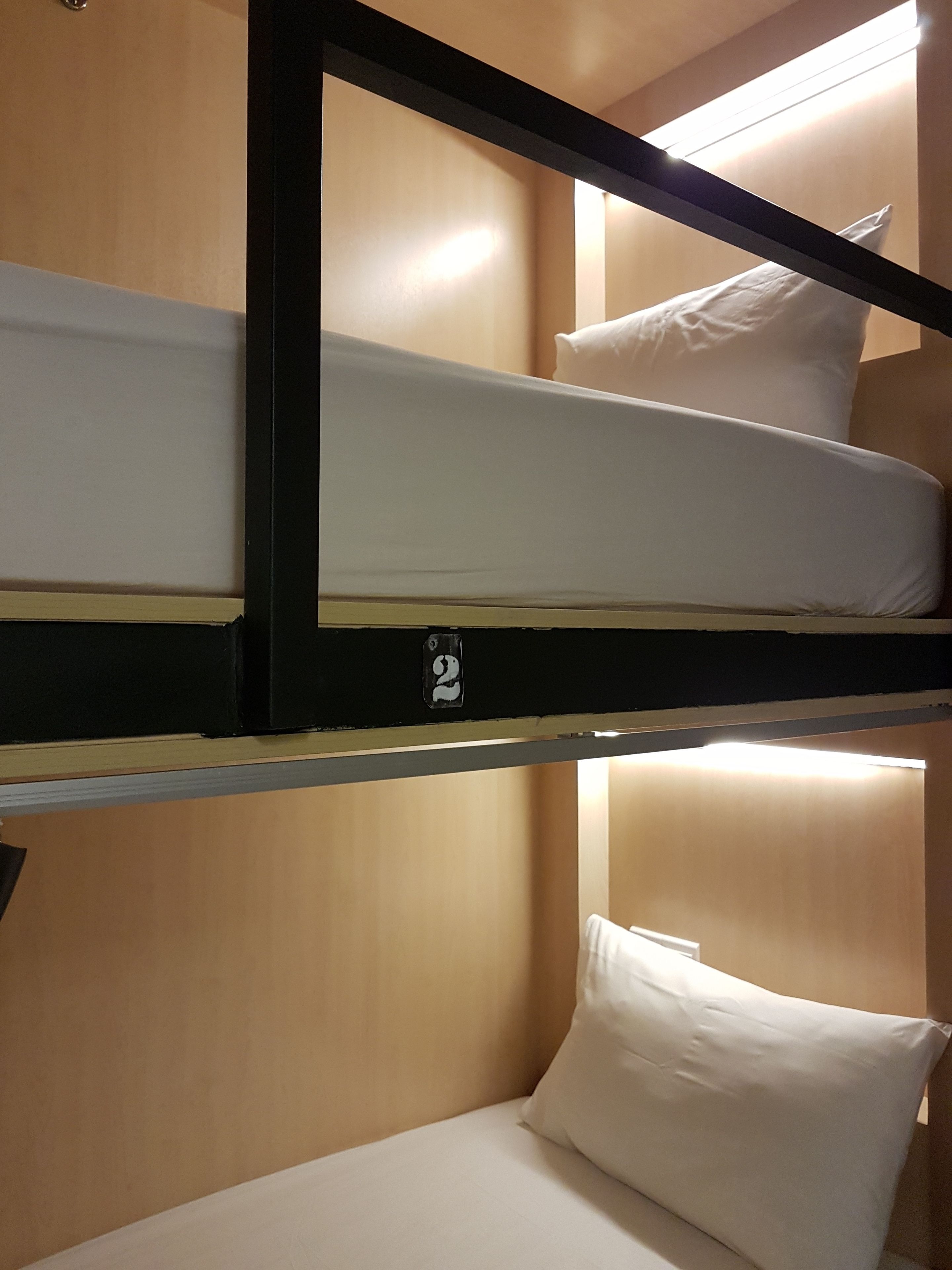 A bunk bed with two levels, each with a pillow and a headboard.