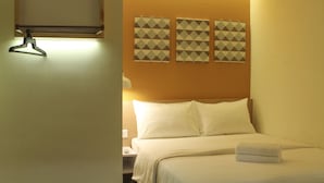 A hotel room with a bed, a nightstand, a lamp, and three wall-mounted picture frames. - 1000 Miles (Kuala Lumpur)